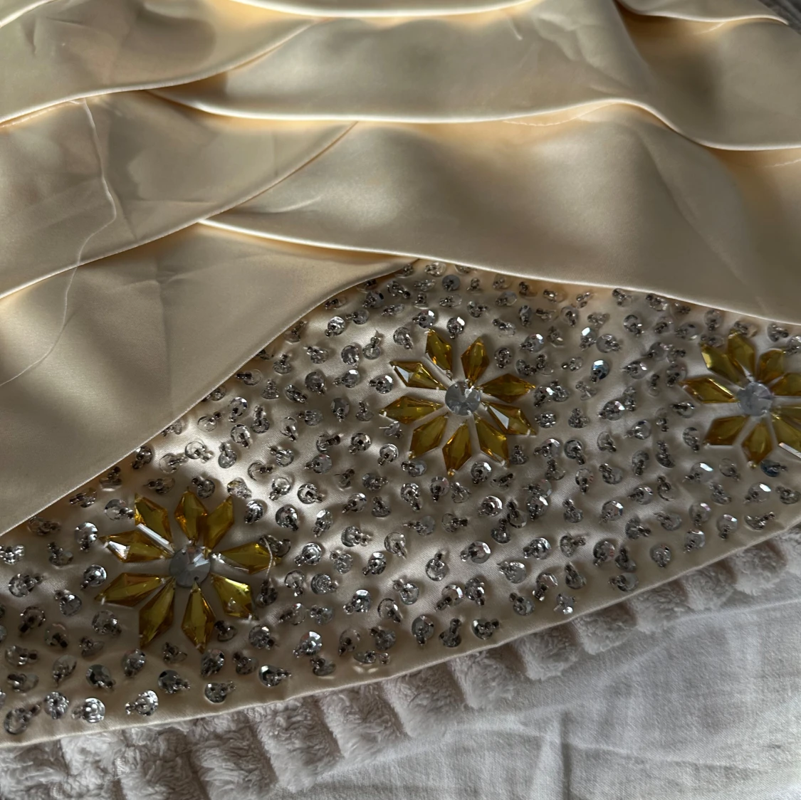 Beige kort klänning med rosett och pärldetaljer - 1