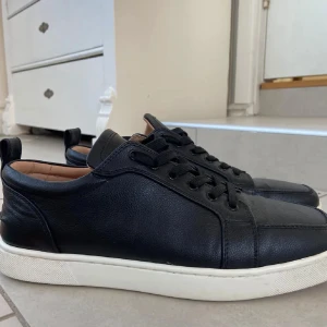 christian louboutin skor - Säljer ett par svarta sneakers i skinn från Christian Louboutin med klassisk röd sula. Skorna är använda väl och ser bra ut. Inann dom sälj tvättar jag självfallet dom.kom gärna med byten eller bud i samma prisklass