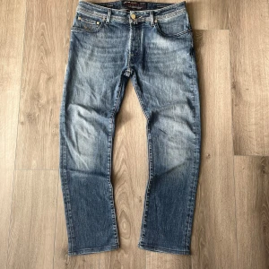 Blå jeans från Jacob Cohen - Snygga blå jeans från Jacob Cohen med klassisk femficksdesign och knappgylf. Tillverkade av exklusiva tyger med italienskt hantverk. Perfekta för en stilren look.