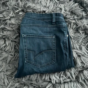Mörkblå dressmann jeansbyxor - Säljer mörkblå dressmann jeans med klassisk femficksdesign och diskreta sömmar på bakfickorna. Byxorna har en dragkedja och knapp framtill. Jeansen har också en loose design. 