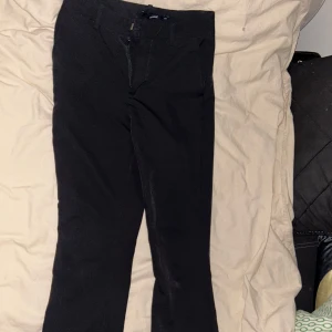 Svarta byxor med dragkedja - Snygga svarta byxor med dragkedja framtill. De har en klassisk design och passar perfekt för en stilren look. Byxorna har en rak passform och är tillverkade i ett bekvämt material ifrån bikbok storlek 34 är 166cm passar perfekt.