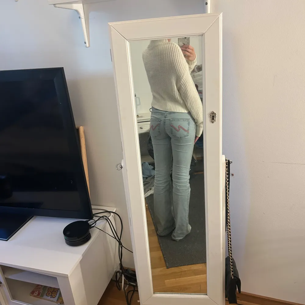 Säljer en stilren vit stickad tröja med hög krage. Tröjan är croppad och har långa ärmar, perfekt för en trendig look. Passar bra till jeans eller kjol för en avslappnad stil.. Neuletakit & Villapaidat.