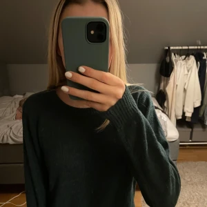 Mörkgrön tröja från Aéryne - Säljer en stilren mörkgrön tröja från vila. Tröjan har en klassisk design med rund hals och långa ärmar. Perfekt för kyligare dagar och lätt att matcha med olika outfits. Helt ny utan prislapp eftersom jag aldrig använt den. Jättefin och superskön. 