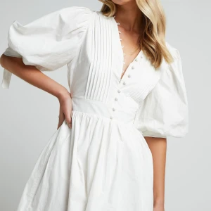 Vit klänning med puffärmar från Showpo - Säljer en helt oanvänd klänning från Showpo #studentklänning #vitklänning 