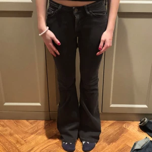 Svarta bootcut jeans från Weekday - Säljer ett par svarta bootcut jeans från Weekday. De har en klassisk femficksdesign och är tillverkade i ett bekvämt denimtyg. Perfekta för en stilren look.