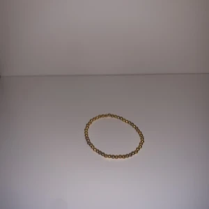 Fint armband med guldiga pärlor - Elegant guldarmband med små pärlor. Perfekt som en subtil accessoar för att komplettera din stil. Armbandet är elastiskt och passar de flesta handleder.⚜️om du har några funderingar är det bara att höra av sig✌️