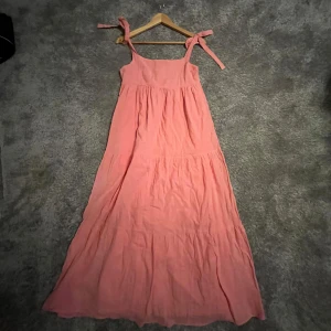 Rosa långklänning med knytband - Luftig rosa långklänning med knytband på axlarna. Perfekt för sommaren ex midsommar