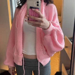 Rosa stickad kofta - Säljer en mysig rosa stickad kofta med långa ärmar och knytband i midjan. Köpte den i Paris second hand, den har inte något specifikt märke så gissar att den är handgjord. Storlek xs/s beroende på hur man vill att den ska sitta. 