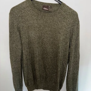 Grön tröja från Oscar Jacobson - Säljer en stilren grön tröja från Oscar Jacobson, tillverkad i Italien. Tröjan har en klassisk design med rund hals och långa ärmar. Perfekt för en elegant och avslappnad look. Tröjan är i väldigt bra skick. Den är perfekt inför sommaren då den är tunn i materialet. Den är storlek L men skulle säga att den sitter någonstans i mellan L-M. Kunden står för frakt, priset går att diskutera