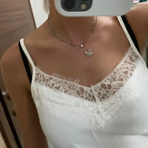 Vit linne med spetsdetaljer - Ett vitt linne med vacker spetsdetalj vid halsringningen. Aldrig använd, enbart testas. Passar Xs/S/M! 