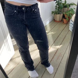 Svarta jeansbyxor - Snygga svarta jeansbyxor med en klassisk femficksdesign. De har en normal passform och är perfekta för en avslappnad stil. Byxorna har en knapp och dragkedja framtill.