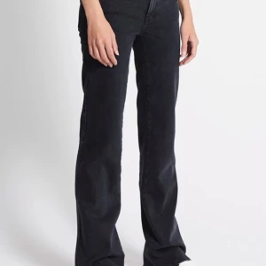 Svarta jeans - Snygga svarta jeansbyxor med låg midja och är 90’s Boot. Byxorna har klassisk femficksdesign och knappar i silverfärg. 
