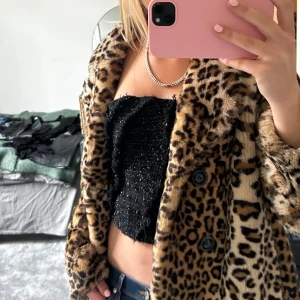 Svart glittrig tubtopp - Snygg svart tubtopp med glittrig yta som ger en festlig känsla. Perfekt för en utekväll eller speciella tillfällen. Toppen är ärmlös och har en tight passform som framhäver figuren.