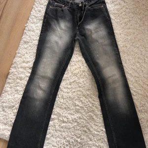Svarta jeans från Lindex - Snygga svarta jeans från Lindex med en cool tvättad look. De har en klassisk femficksdesign. Perfekta för en avslappnad stil med en touch av edge. Passar bra till både sneakers och boots. Mkt bra skick. Stl 40 och stretchiga.