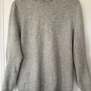 Grå stickad hoodie - Säljer en stilren grå stickad hoodie. Väldigt bra skick och storlek M men passar L. Stickad i bomull