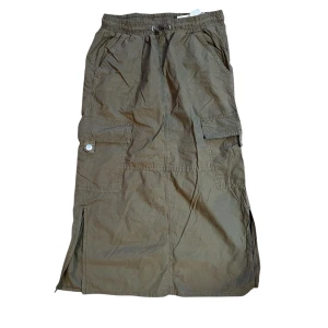 Cargo maxikjol från Stradivarius - Snygg olivgrön långkjol från Stradivarius med praktiska fickor och justerbar i midjan. Kan därför användas både som low waist och highwaist. Kjolen har en avslappnad passform och är perfekt för en casual look. Har även slitsar på sidorna för extra rörelsefrihet. Använd fåtal gånger och därför i nyskick.