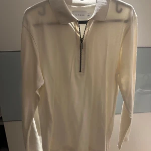 Vit långärmad tröja från Topman - Säljer en stilren vit långärmad tröja från Topman med dragkedja framtill. Perfekt för en avslappnad och snygg look. Tröjan har en klassisk krage och är tillverkad i ett mjukt material.