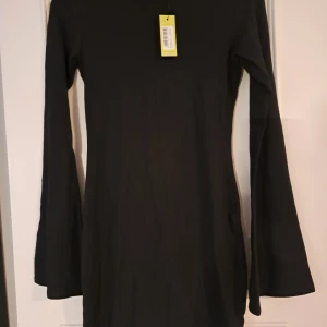 Svart klänning från Boohoo - Snygg svart klänning från Boohoo med långärmad design. Perfekt för en stilren look. Klänningen har en enkel och elegant passform som passar till många tillfällen.