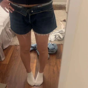 Jeansshorts Levi’s - Snygga mörkblå jeansshorts från Levi's med fransiga kanter och klassisk femficksdesign. Perfekta för en avslappnad stil. De har en knappgylf och är tillverkade i slitstarkt denim.