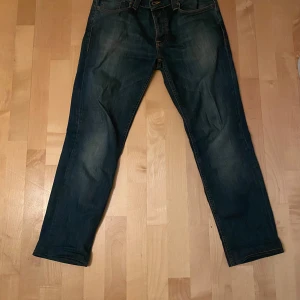 Blå jeans från Nudie Jeans - Säljer ett par klassiska blå jeans från Nudie Jeans. De har en snygg tvätt och skick som 8/10. 