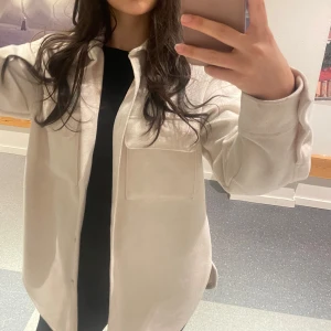 Beige overshirt - Säljer en stilren beige overshirt med knappar framtill. Jackan har en fin passform och en praktisk bröstficka. Perfekt för lager-på-lager-stil.   Den är i väldigt bra skick 😍