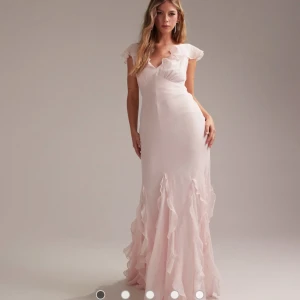 Ljusrosa långklänning med volangdetaljer - Säljer dennna ljusrosa balklänning med volanger från ASOS. Den är endast provad med prislappen kvar. 