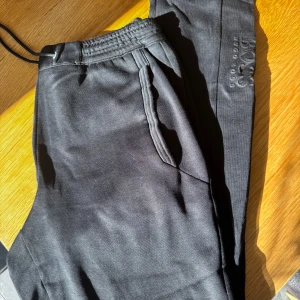 Svarta mjukisbyxor från Hugo Boss - Snygga svarta mjukisbyxor från Hugo Boss. Rensar ur min garderob från en hel del oanvända kläder🌼 Om du ser något mer i min profil som du gillar så skickar jag med det till dig också!😊 Fler kläder kommer! 