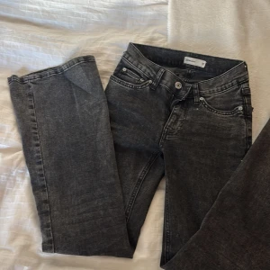 Grå jeans från Gina - Snygga grå jeans från Gina med klassisk femficksdesign och knappgylf. Perfekta för en stilren look.