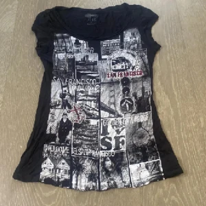 Svart t-shirt med San Francisco-tryck - Cool svart t-shirt med ett collage av San Francisco-motiv i grått och vitt. T-shirten har korta ärmar och en rund halsringning. Perfekt för dig som älskar stadens vibe! Diamanter på den❤️