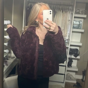 Vinröd pälsjacka - Säljer en mysig vinröd pälsjacka med knappar. Jackan är från vero moda och är i stolek Xs. Men skulle säga att den även passar S och M. Jätte fin och skönt material innuti då det är silkes.
