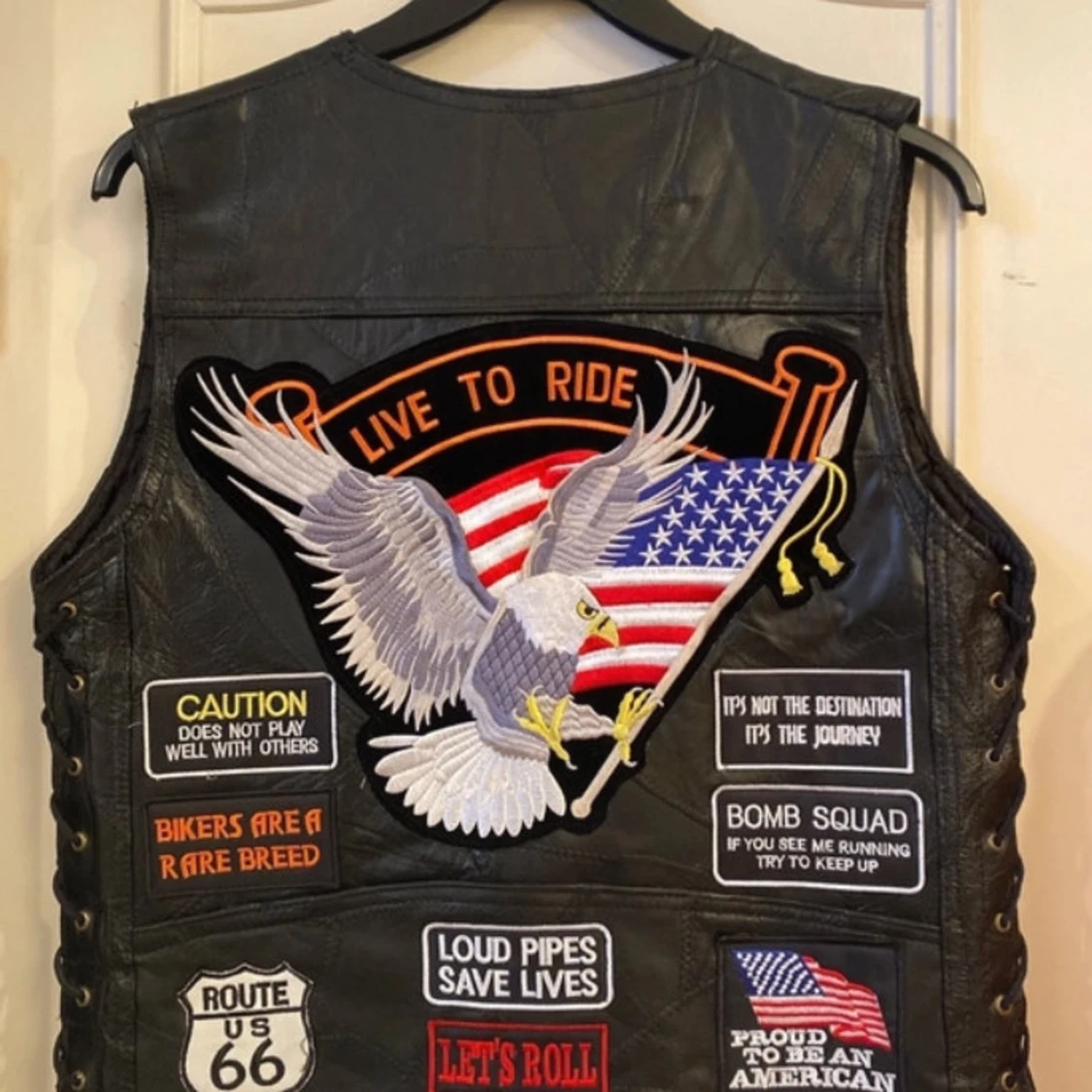 Svart skinnväst med patchar