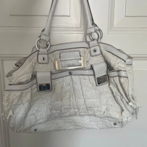  Väska från guess  - Vit axelväska från Guess, rätt stor & med många olika fickor så den får plats med mycket. Väskan flagnar, som man ser i bilderna. Det går att fixa men jag har ej tid & säljer därför den. 
