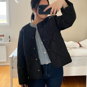 Svart quiltad jacka - Säljer en svart quiltad jacka med knappar. Jackan har en normal passform och är perfekt för våren och höst. Den är stilren och lätt att matcha med olika outfits. Den är helt ny, original pris 699kr. Storlek M men passar perfekt på S också beroende på hur man vill att den ska sitta, jag är vanligt S men tog M i denna då den satt finare.