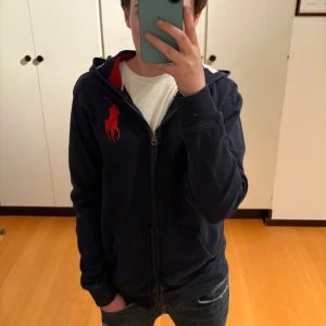 Ralph lauren hoodie (XS) - Säljer nu min sjukt snygga Ralph lauren zip hoodie i sjukt bra skick. Den är i storlek 14-16 vilket motsvarar ungefär XS i vuxenstorlek. Modellen är 166cm lång. Hör av dig vid funderingar!
