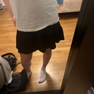 Svart kjol från Gina Tricot - Snygg svart kjol från Gina Tricot med volangdetaljer. Är i xxs men passar mig som brukar bära xs/s 🤗har nästan aldrig används ❤️