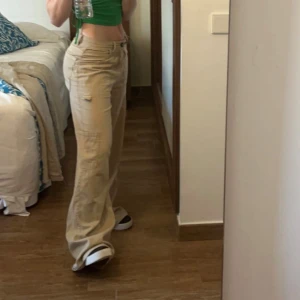 Beige Cargo Straight Pant från Bershka - Snygga beige cargobyxor från Bershka med straight fit. Då de är lite långa för mig (jag är 160 cm) och jag inte har orkat lägga upp dem så har de endast använts en gång. Något smutsiga i nederkanten baktill eftersom att de är för långa för mig (se sista bilden)🥰