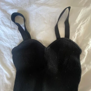 Svart ribbad korsett - Snygg svart ribbad korsett med breda axelband. 