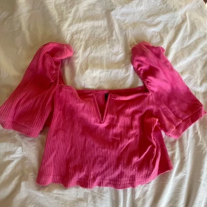 Rosa ribbad topp från Shein - Säljer en söt rosa ribbad topp från Shein med korta puffärmar och en v-ringad design. Perfekt för en somrig look!