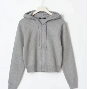 Grå hoodie med dragkedja - Säljer en stilren stickad tröja med dragkedja och justerbara snören i huvan. Tröjan har långa ärmar och ribbade muddar vid ärmslut och nederkant samt en luva. Kom privat för fler frågor💕 köparen står för frakt!! Använd 2 gånger