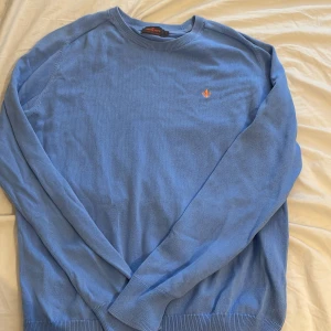 Blå tröja från Morris - Säljer en snygg blå tröja från Morris i 100% Pima Cotton. Tröjan har en broderad orange detalj på bröstet och långa ärmar. Perfekt för en stilren look. Hör av dig vid intresse! Två stycken defekter som inte syns. (Bild 4 och 5) nypris är 1200. Defekterna är i armhålorna 