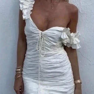 Vit zara klänning - Snygg vit axelbandslös klänning med volangdetaljer och snörning framtill. Perfekt för sommarens fester. Den korta längden ger en chic look.