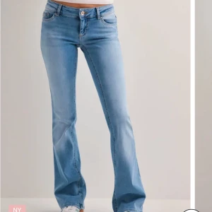 Blå bootcut jeans - Snygga blå bootcut jeans med låg midja. De har en klassisk femficksdesign och en knappgylf. Perfekta för en avslappnad stil.