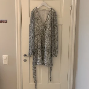 Zebramönstrad klänning från Gina Tricot - Säljer en snygg zebramönstrad klänning från Gina Tricot i storlek S. Klänningen har långa ärmar och ett knytband i midjan för en fin passform. Inte använd mycket💕