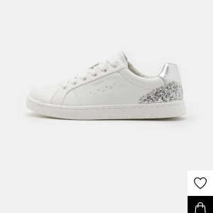 Vita sneakers med glittrig detalj - Snygga vita sneakers med en glittrig silverdetalj på hälen. Skorna är väl använda därav priset men går enkelt att få dom en uppfräschning. Snygga skor som funkar till allt