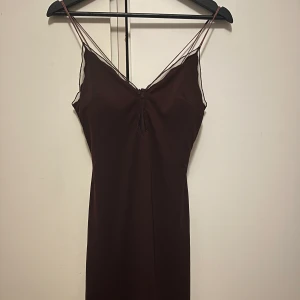 Mörkbrun klänning med tunna axelband - Elegant mörkbrun klänning med tunna axelband .