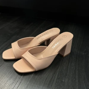 Beige klackskor - Snygga beige klackskor från Boohoo med öppen tå. Perfekta för en stilren look med en bekväm blockklack. Aldrig använda