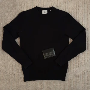 Svart tröja från Bläck - Säljer en svart oanvända tröja från Bläck. Tröjan har ett diamantmönster och sitter relativt tajt på kroppen. PLÅNBOKEN FÖLJER EJ MED!