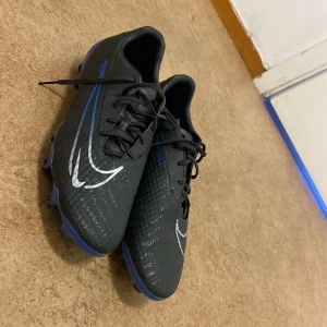 Svarta fotbollsskor från Nike - Säljer ett par svarta fotbollsskor, endast använda en gång. I nyskick! Storlek 44 (passar mig som har 42). Pris: 800kr