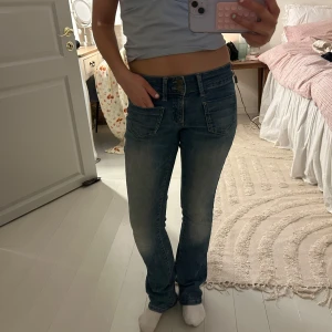 Lågmidjade jeans💘 - Snygga blå bootcut jeans med låg midja, kom privat för mått💘har lite slitningar längst ner vid jeansen!