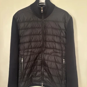 Moncler cardigan  - Moncler Cardigan. Size M. Svart, fint skick utöver en liten skavank på mudden se bild! Pris 4090kr.